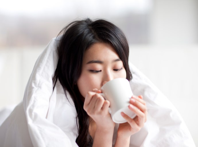 温かいお茶を飲みながらリラックスする50代女性