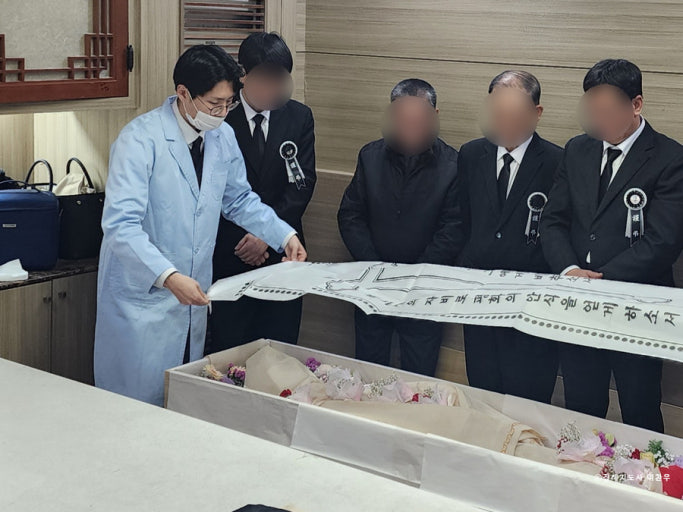 Bàn thờ cúng (빈소) được trang hoàng với di ảnh, nến, hương và hoa cúc trắng.