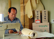 전남 보성읍 한 수의제작 공장에서 한 장인이 수의를  만드느랴  여념이 없다.수의는