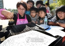 전통 방식 인쇄 체험하는 어린이들