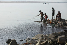 오염된 강에서 물고기 낚는 사람들