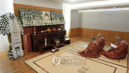 하얀 국화에 둘러싸인 앙드레 김