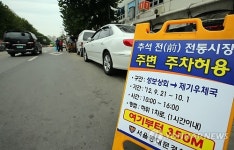 재래시장 앞에 줄지어 서 있는 차들