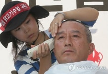 삭발하는 양계 농민