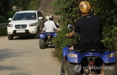 좁은 길 달리는 4륜 오토바이