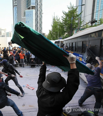 경찰 버스 끌어내는 노동절 집회 참가자들