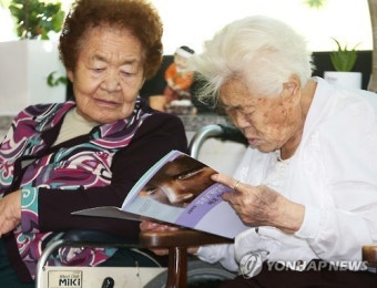 '위안부 바로알기 교재 살펴보는 할머니들'