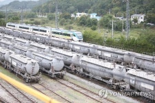 멈춰선 화물열차 옆 지나는 여객열차