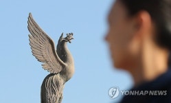 봉황 조형물 바라보는 관광객