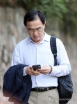 휴대전화 보는 조명균