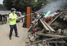 폐기물 더미에 소독약 뿌리는 보건소 직원