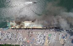 검은 연기 피어오르는 중고차 수출선박
