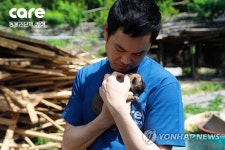 구출한 강아지를 안고 있는 리처드 용재 오닐