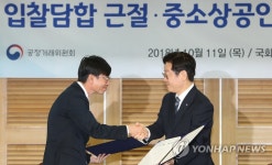 업무협약서 교환하고 악수하는 김상조와 이재명