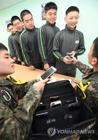 당직사관에게 휴대전화 건네받는 장병