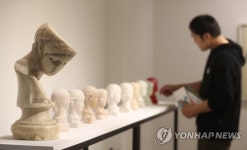 조각상 살펴보는 관람객