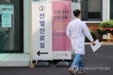 선별진료소 앞 지나가는 의료진