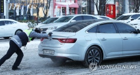 눈길에 멈춘 차량 밀어주는 경찰