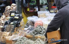 마른 멸치 진열하는 제주 동문시장 상인