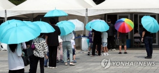 폭염에 양산 든 코로나19 검사자들