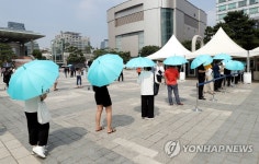 폭염에 양산 든 코로나19 검사자들