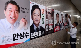 국민의힘 대선 경선 예비 후보 포스터 부착하는 당직자