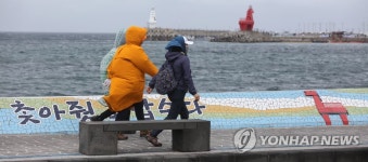 한산한 바닷가 걷는 여행자들