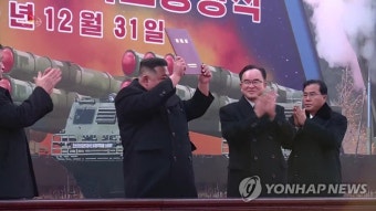 방사포 증정서 들어 보이는 김정은