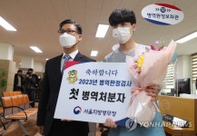김주영 서울지방병무청장과 기념촬영하는 올해 첫 병역처분자