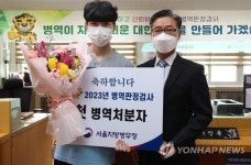 김주영 서울지방병무청장과 기념촬영하는 올해 첫 병역처분자