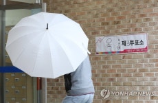 우산 쓰고 투표소로