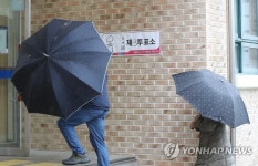 우산 쓰고 투표소로