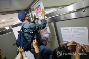 사퇴 촉구 손팻말 붙이는 유가족들