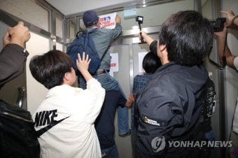 사퇴 촉구 손팻말 붙이는 유가족들