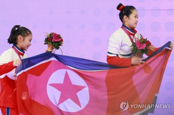 안창옥-김선향, 인공기 들고 시상대로