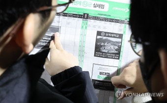 입시 참고표 살펴보는 수험생들
