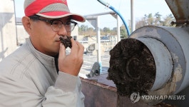 돼지 분뇨에서 분리된 고형물 냄새 맡는 동백팜 고정훈 대표