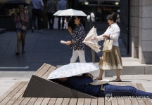 따가운 햇빛 아래 양산 덮고 휴식