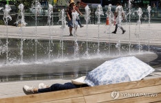 따가운 햇빛 아래 양산 덮고 휴식