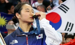 올림픽 금메달에 입 맞추는 안세영