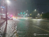 집중호우 때 침수된 도로 통제하는 경찰