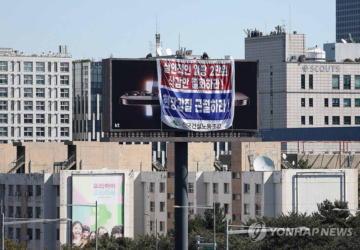 민주노총 건설 노동자들, 국회 인근 광고탑에서 고공농성 현장 일당 2만 원 삭감안 철회를 요구