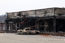 불에 탄 주유소 옆 건물과 차