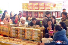 길주군 지방공장 식료품 코너서 제품 살펴보는 주민들