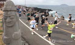 비양도가 보이는 해안도로 달리는 마라토너들