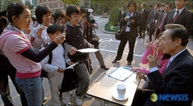 아이들의 핸드폰 카메라에 포즈취하는 이명박