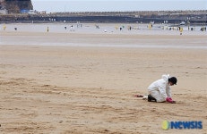 넓은 모래사장 위의 자원봉사자