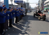 박수치는 운동원들 앞을 지나는 경운기