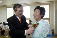 카네이션 달아주는 김경택 이사장