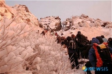 해를 등에 지고 천왕봉 오르는 탐방객들